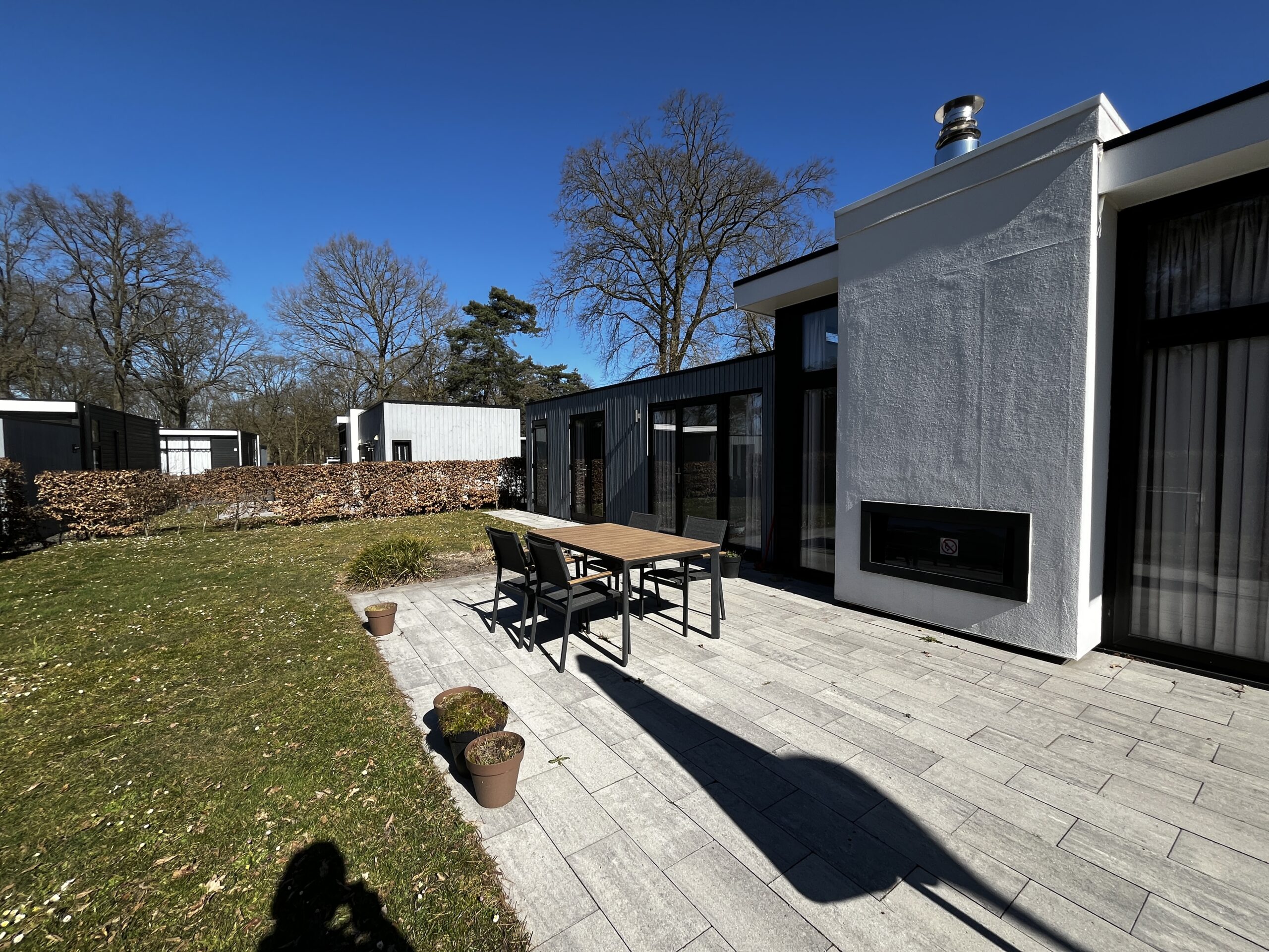 De voorkant van de recreatiewoning met een tuinset en een ruime tuin