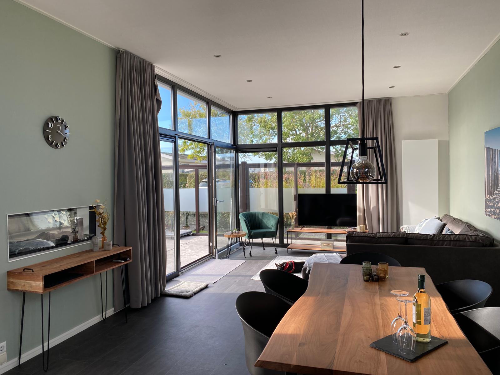 Binnen in het vakantiehuis staat een eettafel en zitplaats met schuifdeur naar buiten